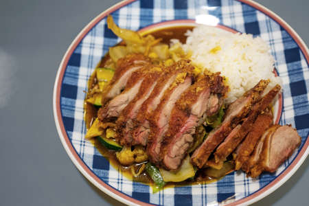 Crispy fried duck meal on vegetables with rice on a patterned plate in a Chinese fast food restaurant, selected focus, narrow depth of fieldの写真素材