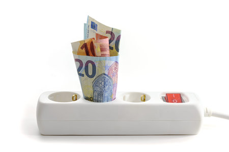 Euro banknotes stuck in an electric triple power strip, concept of increasing energy costs, home...
