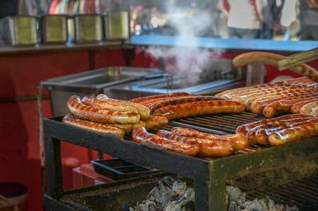 Hot sausages on a street grill, typical fast food on a German county fair or Christmas market, selected focus, narrow depth of fieldの写真素材