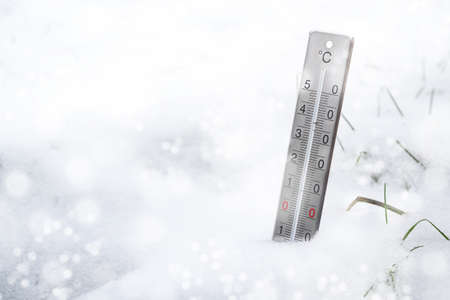 Thermometer in the snow during a cold snap in winter, concept for weather phenomena, climate change and rising heating costs, copy space, selected focus, narrow depth of fieldの写真素材