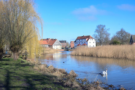 Mill pond of the small town Rehna with park and old town houses against the blue sky in...