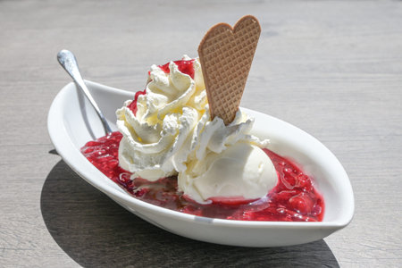 Ice cream with whipped cream, wafer cookie and red fruit jelly, in Germany called rote gruetze,...