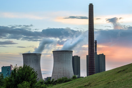 Heavy power plant industry, chimney and towers with pollution at the HKM steelworks in Duisburg, Germany against a cloudy sky at sunset, copy space, selected focusのeditorial素材