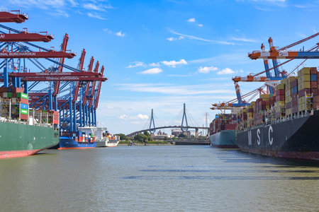 Hamburg, Germany, August 3, 2022: Cargo port with terminals, cranes, container ships and the Koehlbrand bridge in the background. Industry and global transport. Copy space, selected focusのeditorial素材