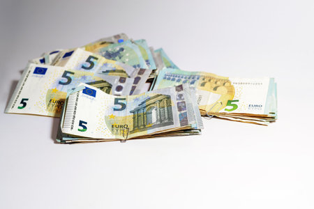Stacks of five-euro banknotes, collected low value can become a lot of money, concept for business, finance or inflation, light gray background, copy space, selected focus, narrow depth of fieldの写真素材