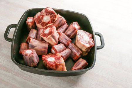 Raw oxtail pieces with bone in a black tray, gelatin-rich meat traditional for a slow-cooking stew or stock base for oxtail soup, copy space, selected focus, narrow depth of fieldの写真素材