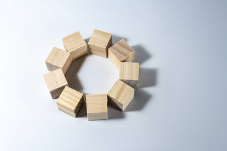 Group of wooden cubes together forming a circle, symbol of teamwork, solidarity and cohesion, light...