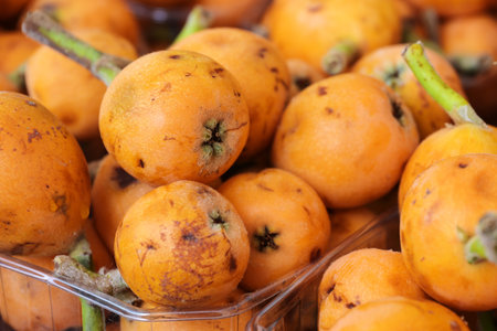 Orange loquat fruits (Eriobotrya japonica) for sale on a farmers market, full frame, selected focus,...