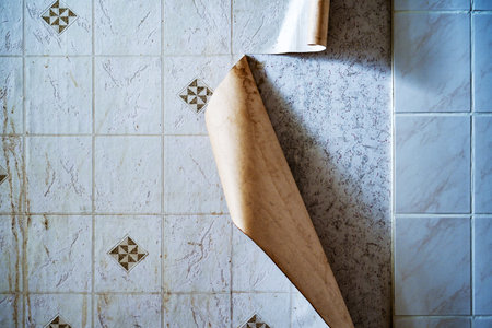 Foil with artificial tiles detaches from the kitchen wall in an old apartment in need of renovation, concept for construction, housing problems and old building property, copy spaceの写真素材