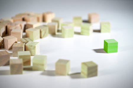 Thinking green, even a single one can bring about change, green wooden cube affects the group of...