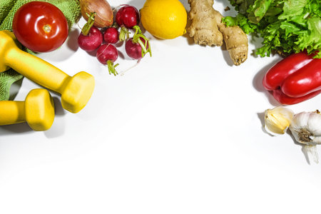 Dumbbells, vegetables and lettuce, fitness concept for a vegetarian healthy slimming diet and sport exercising, top view from above on a white background, copy space, selected focusの写真素材