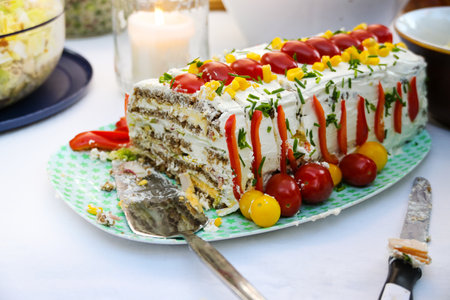 Savory layer cake made from cream cheese, bread, tomatoes, bell peppers and herbs, homemade dish on the buffet at a party, selected focus, narrow depth of fieldの写真素材