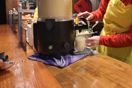 Both at the Christmas market with a wooden bar selling hot alcoholic drinks such as eggnog and mulled wine, selected focusの写真素材