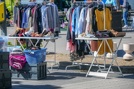 Flea market stall with used clothes, bags and shoes for sale on a sunny day, selected focus, narrow depth of fieldの写真素材