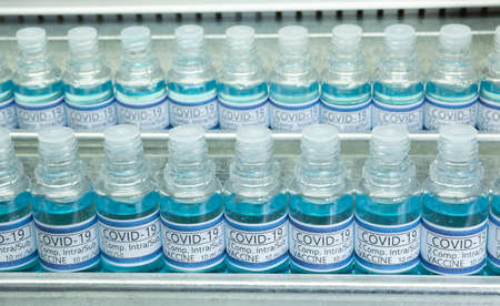 Covid 19 Vaccine Ampoules. Two lines of blue vaccines in some lab or industrial line production.の写真素材