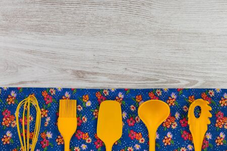 Set of kitchen utensils. Floral pattern cloth napkin on empty wooden background. Top view with space for your text.の写真素材