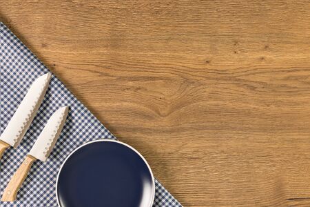 Plate and knives on wooden table background. Top view with space for your text.の写真素材