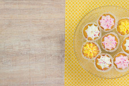 Colorful cupcakes on a wooden table background. Top view with space for your text.の写真素材