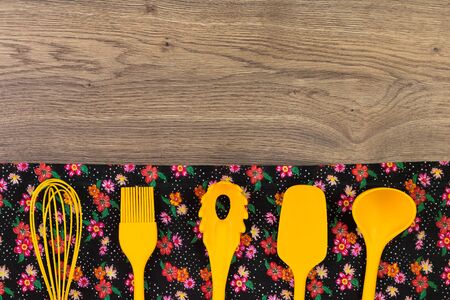 Set of kitchen utensils. Floral pattern cloth napkin on empty wooden background. Top view with space for your text.の写真素材