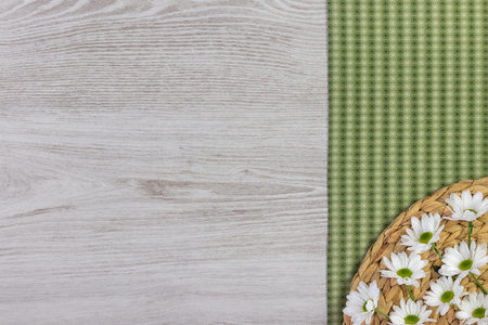 Fresh spring flowers and cloth napkin on white wooden plank. Flat lay, top view with space for your...