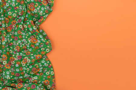 Floral pattern tablecloth on empty orange background. Top view with space for your text.の写真素材