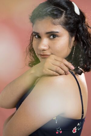 curly hair brunette woman with flowers in studioの写真素材