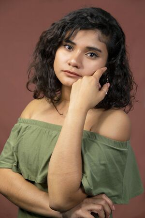 Hispanic brunette girl with curly hair in studioの写真素材