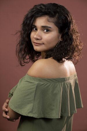 Hispanic brunette girl with curly hair in studioの写真素材