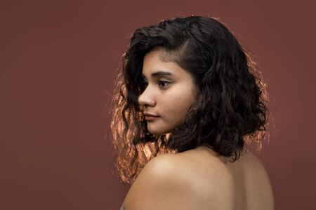 brunette woman with curly hair in studioの写真素材
