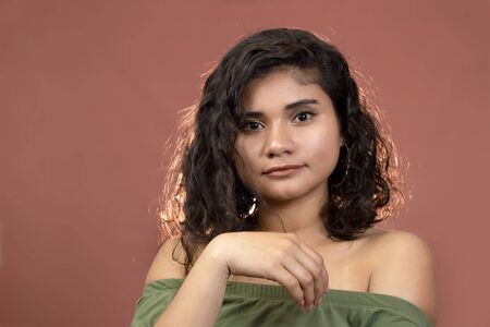 Hispanic brunette girl with curly hair in studioの写真素材