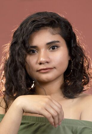 Hispanic brunette girl with curly hair in studioの写真素材