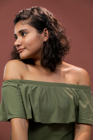 Hispanic brunette girl with curly hair in studioの写真素材