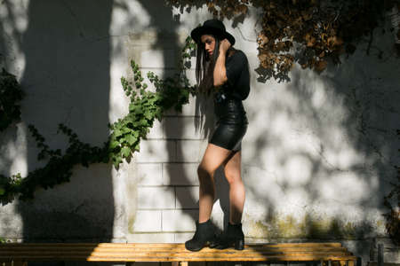 hipster girl posing in a garden with a hat and heavy styleの写真素材