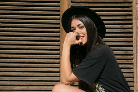 hipster girl posing in a door with a hat and heavy styleの写真素材