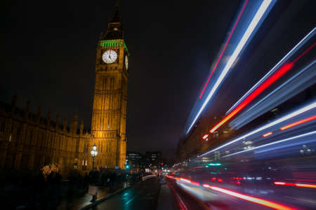 A bus passing in the road to Big Ben at night, Londonの写真素材