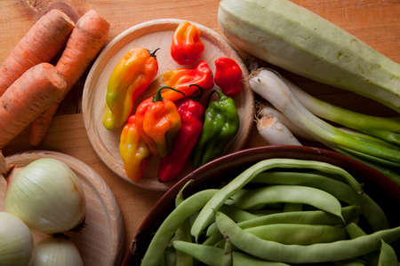 Prepare healthy vegetarian food ingredients, potatoes, carrots, onions, chili, beans, chives and zucchiniの写真素材