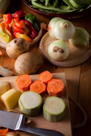 Prepare healthy vegetarian food ingredients, potatoes, carrots, onions, chili, beans, chives and zucchiniの写真素材