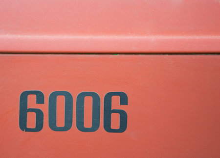 Blacks numbers (6006) on a red background.
