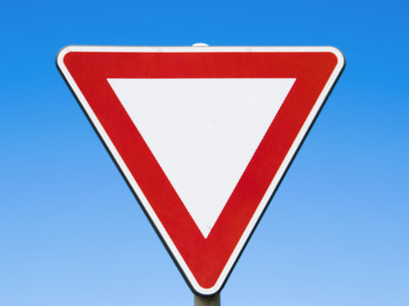 Red and white traffic sign on blue sky.の写真素材