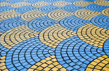 Decorative colorful sidewalk pavement. Tiled floor with yellow and light blue tiles, full frame background pattern.の写真素材
