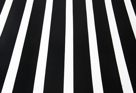 Pedestrian crossing road marking, white lines over black asphalt pavement.の写真素材