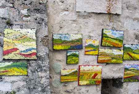 Colored paintings on canvas hung on the wall, Italian street.のeditorial素材