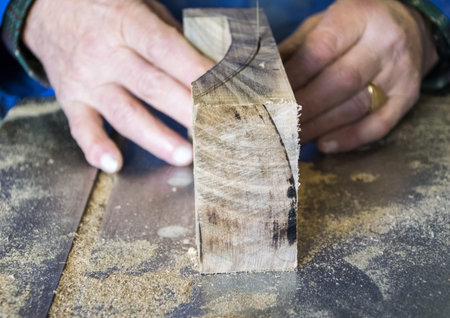 Carpenter Carpenter workplace- workplace. Man using saw to cut wood.