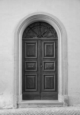 Wooden door in an old Italian house, black and white.の写真素材