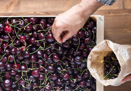 Greengrocer sells cherries at the store. Top view