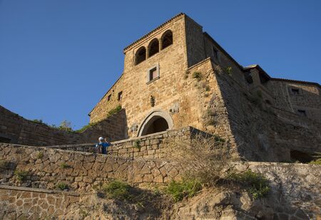CIVIT OF BAGNOREGIO, ITALY - JULY 2017- Tourist takes photographs in a old town during sunsetのeditorial素材