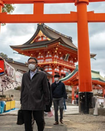 Kyoto, Japan/ March 7, 2020/ businessman with disposable face masks exiting the Fushimi Inari Taisha shrine during the COVID-19 pandemicのeditorial素材