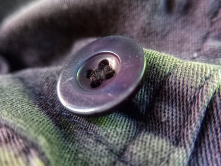 Close up of a metal button on a military jacket. Selective focus.