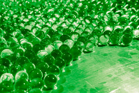 Water green gel balls with bokeh. Polymer gel. Silica gel. Balls of green hydro-gel. Crystal liquid ball with reflection. Green balls texture background.の写真素材