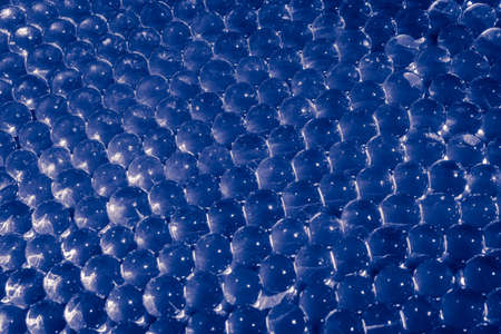 Water blue gel balls with bokeh. Polymer gel. Silica gel. Balls of blue hydrogel. Crystal liquid ball with reflection. Blue balls texture backgroundの写真素材